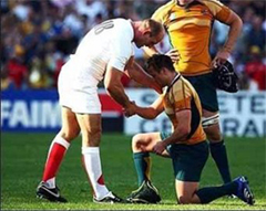 english rugby player helping up an australian rugby player